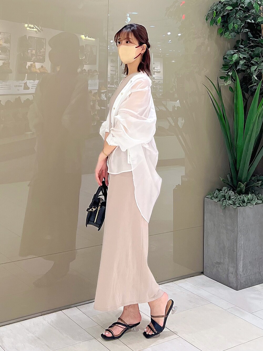 ベージュ系のワンピース、ブラック系のハンドバッグ、ブラック系のサンダルを着用したレディースの春コーディネートの10枚目の写真