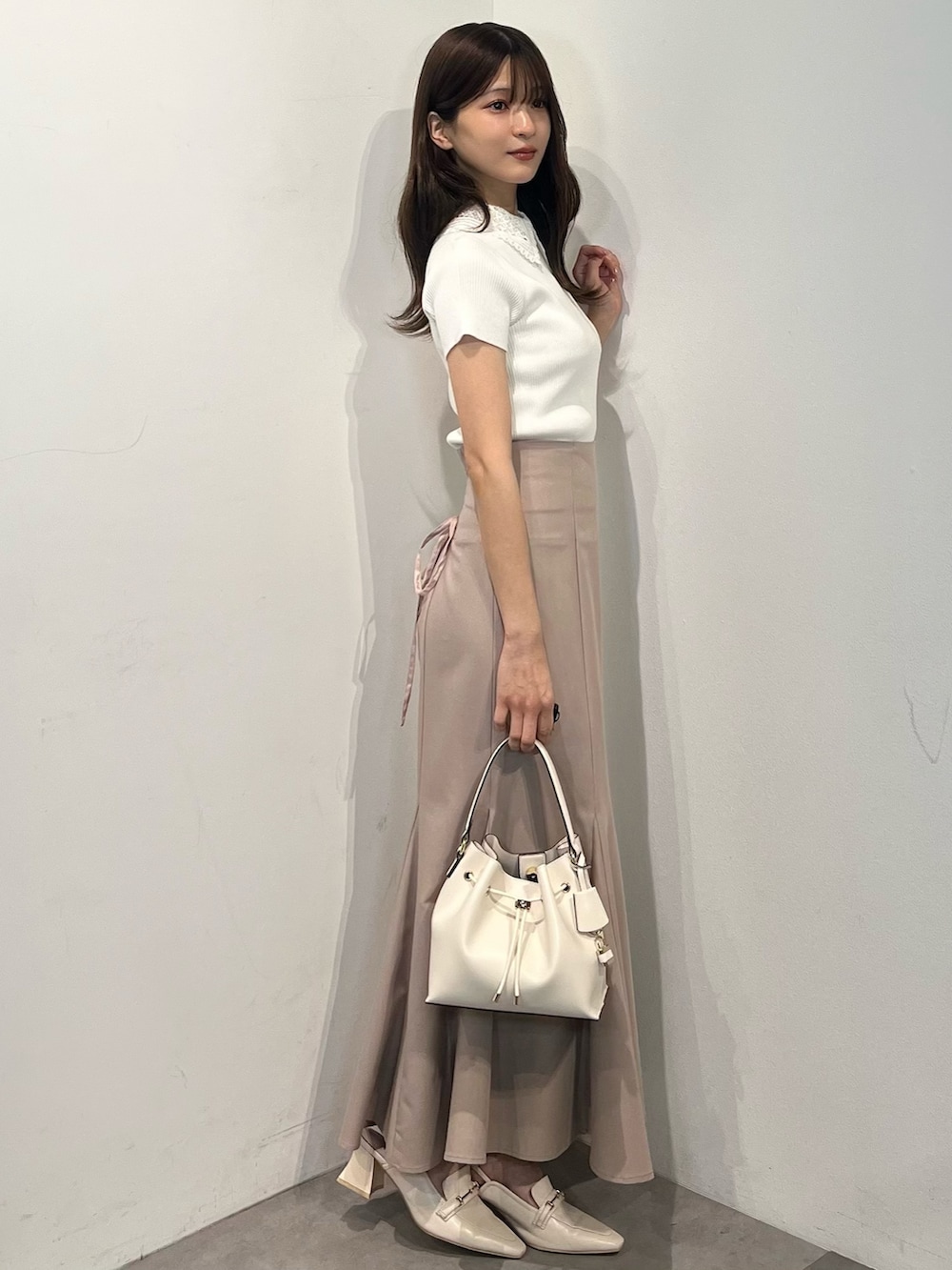 ホワイト系のニット/セーター、ピンク系のスカート、ホワイト系のパンプスを着用したレディースの春コーディネートの5枚目の写真