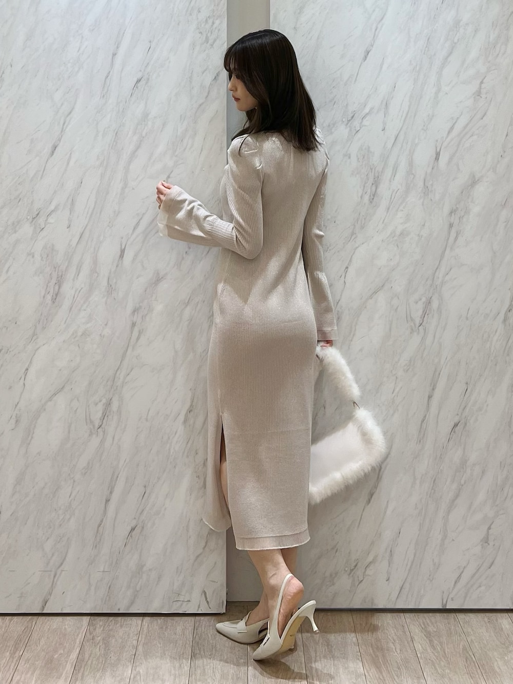 ホワイト系のワンピース、ホワイト系のショルダーバッグ、ホワイト系のパンプスを着用したレディースの冬コーディネートの2枚目の写真