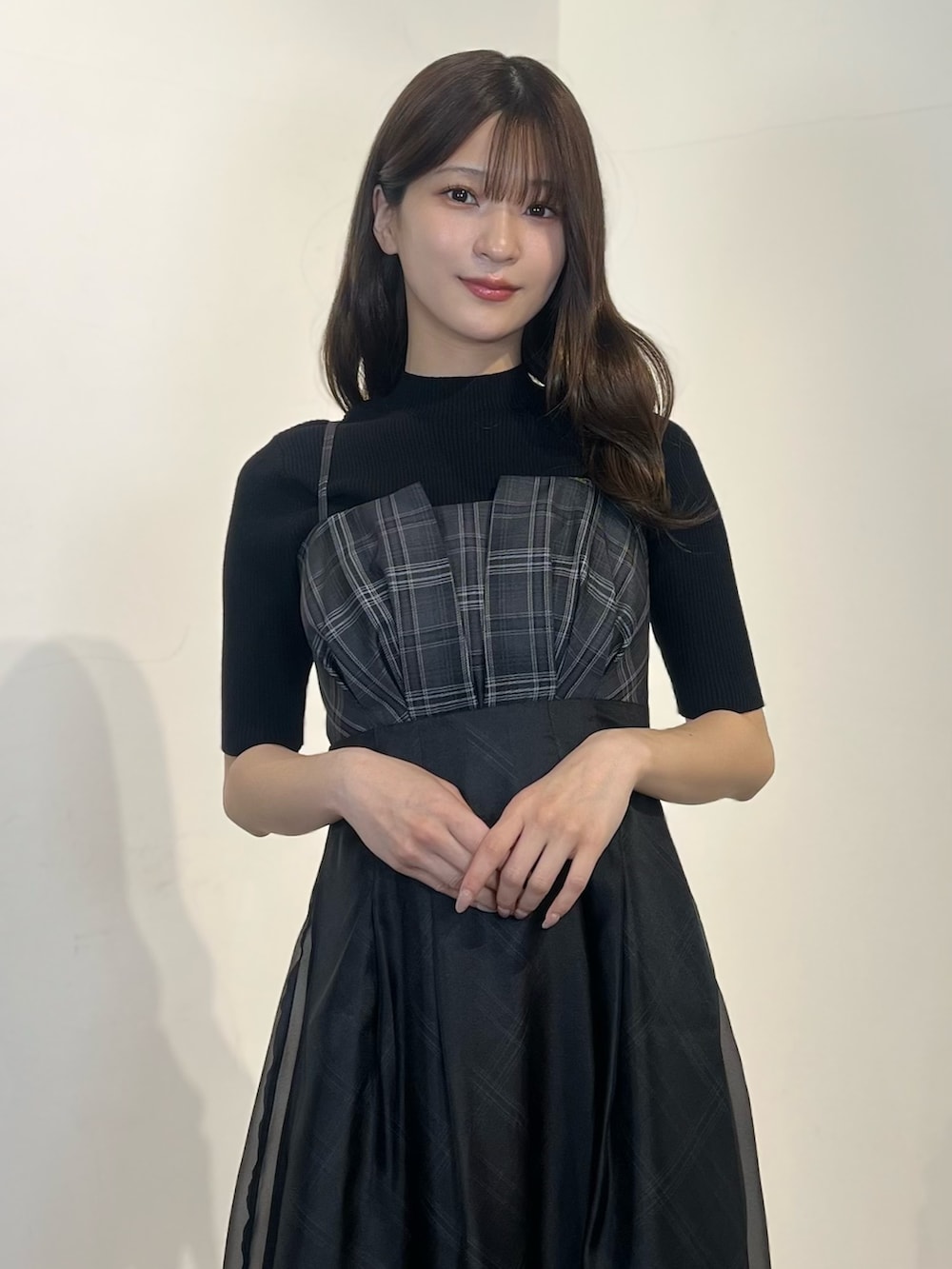 ブラック系のニット/セーター、ブラック系のワンピース、ブラック系のサンダルを着用したレディースの春コーディネートの2枚目の写真