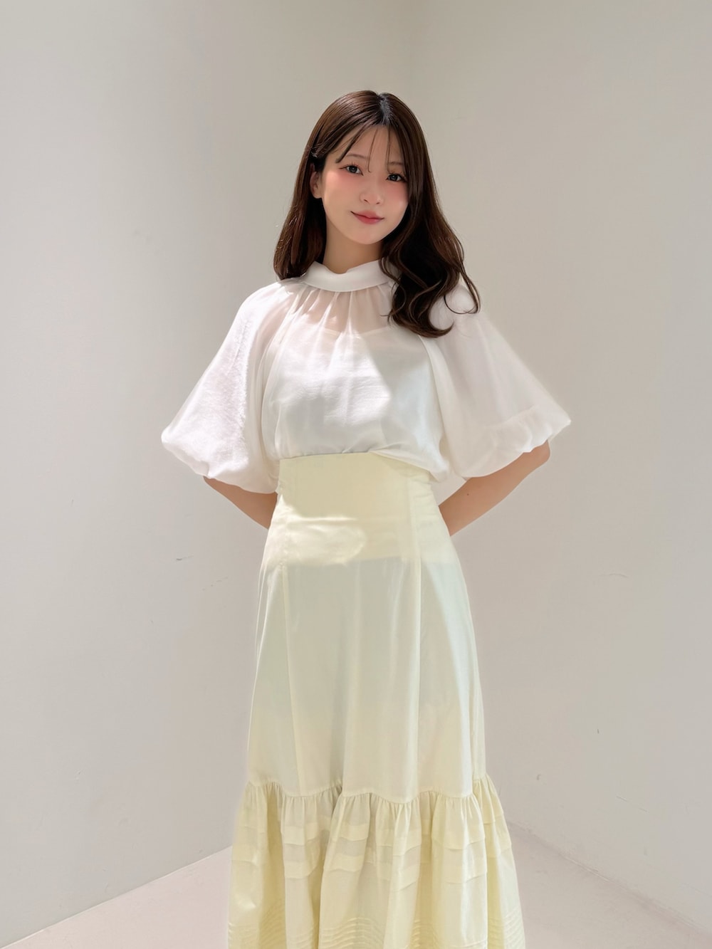 ホワイト系のシャツ/ブラウス、イエロー系のスカート、ホワイト系のパンプスを着用したレディースの春コーディネートの2枚目の写真