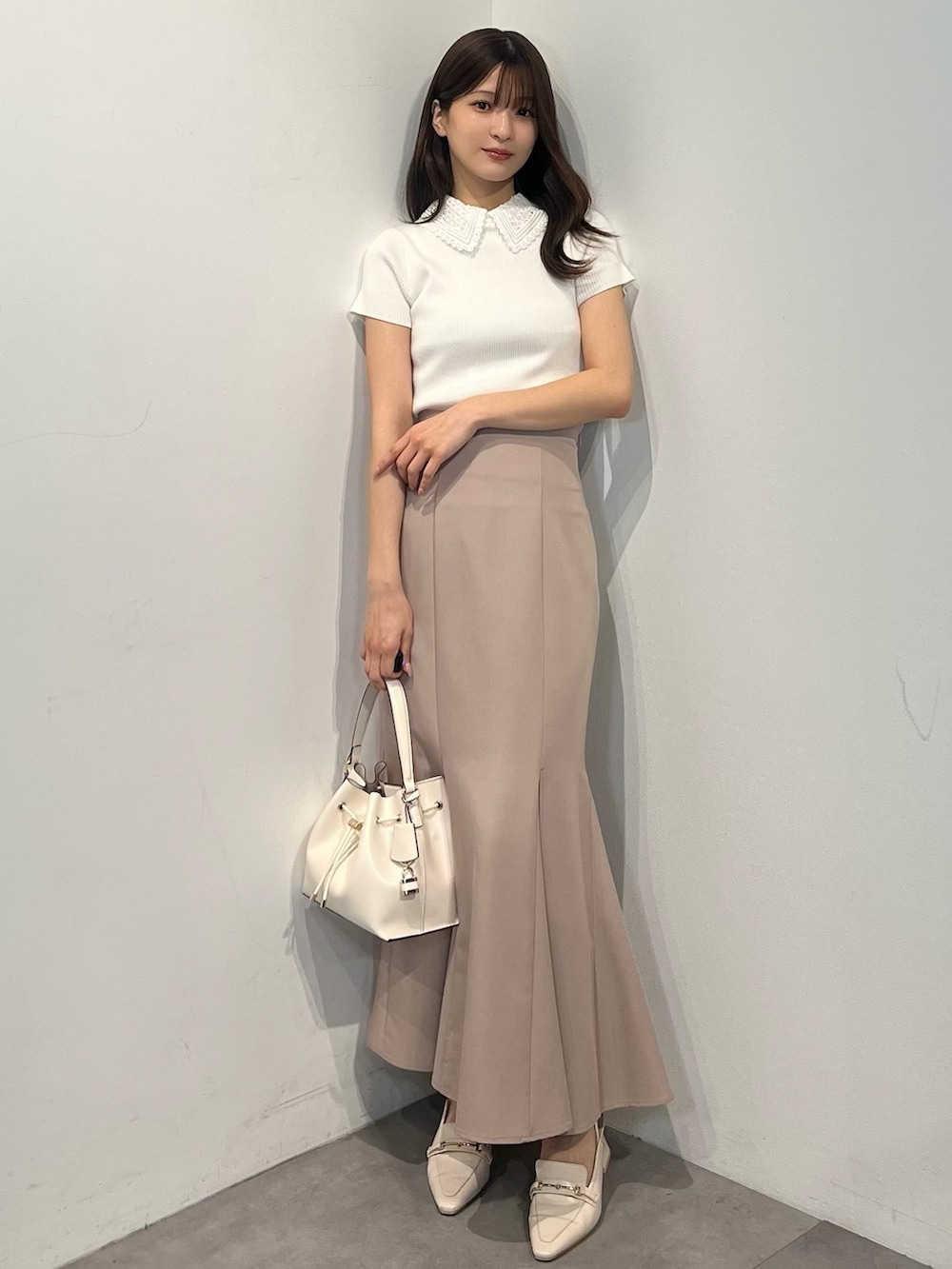 ホワイト系のニット/セーター、ピンク系のスカート、ホワイト系のパンプスを着用したレディースの春コーディネートの3枚目の写真