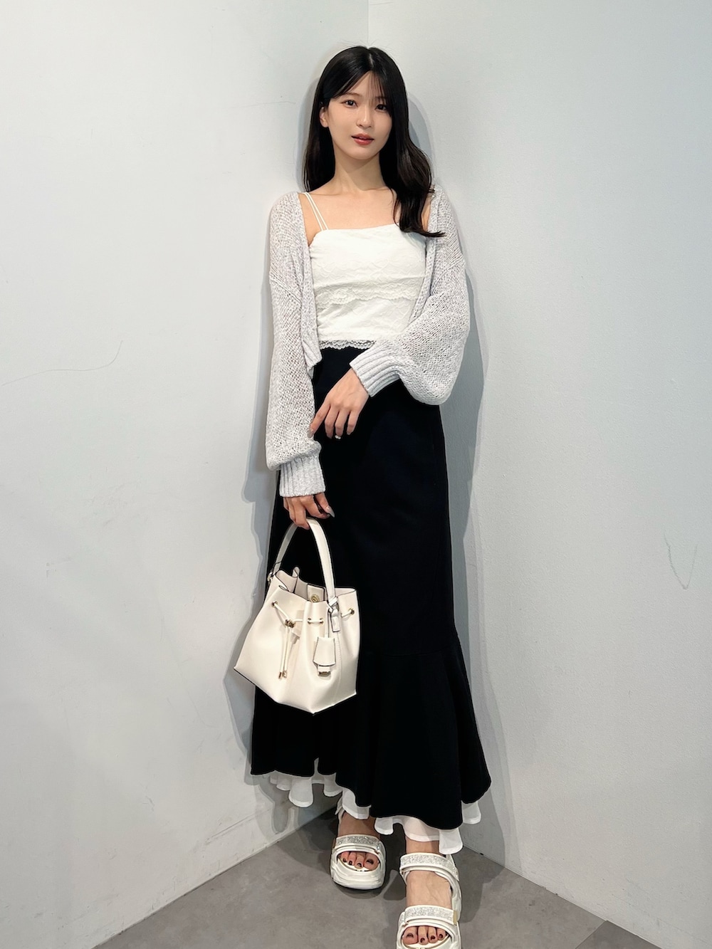 グレー系のカーディガン/ボレロ、ホワイト系のTシャツ/カットソー、ブラック系のスカートを着用したレディースの夏コーディネートの7枚目の写真
