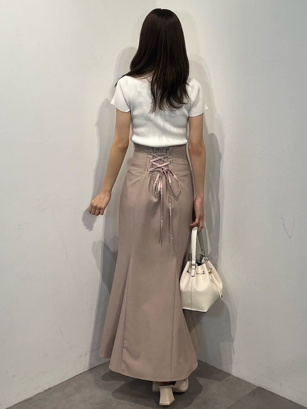 ホワイト系のニット/セーター、ピンク系のスカート、ホワイト系のパンプスを着用したレディースの春コーディネートの6枚目の写真