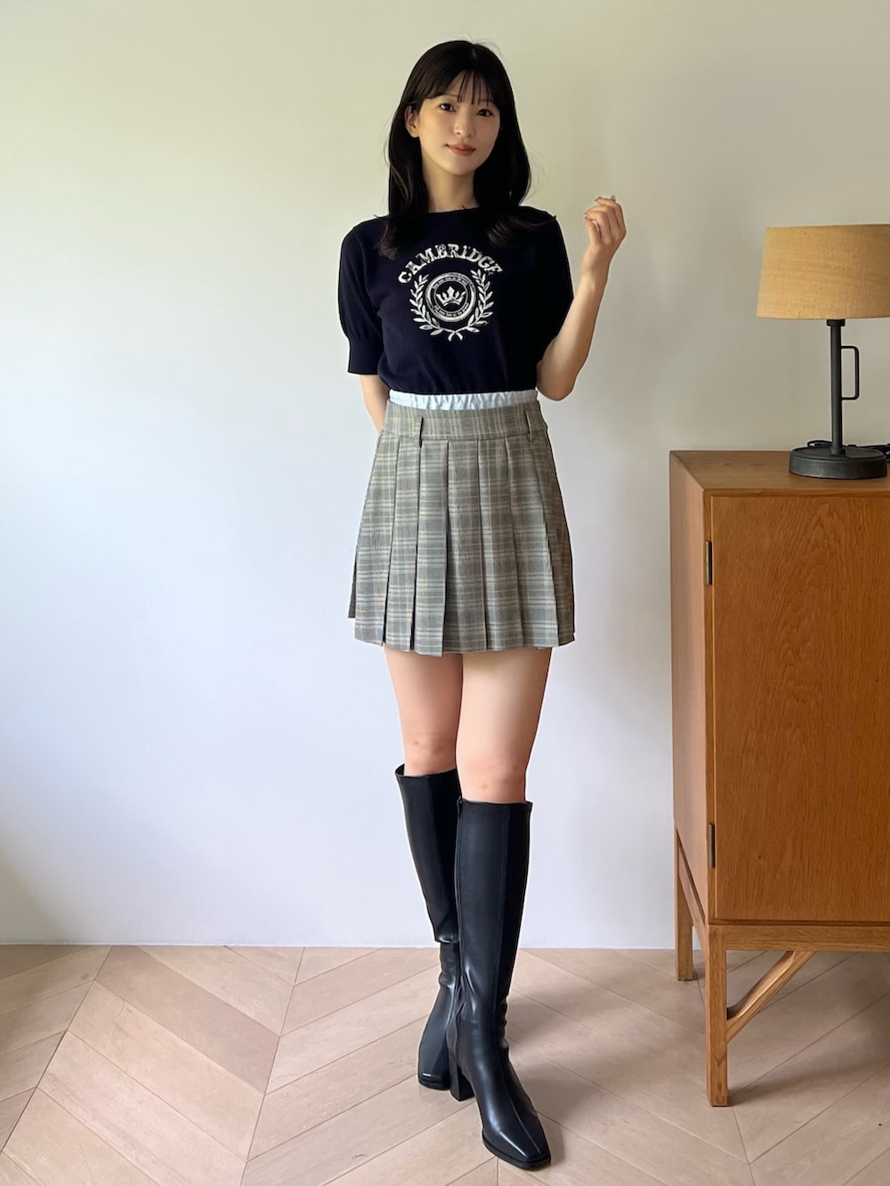 ブルー系のニット/セーター、グレー系のスカート、ブラック系のブーツを着用したレディースの夏コーディネートの2枚目の写真