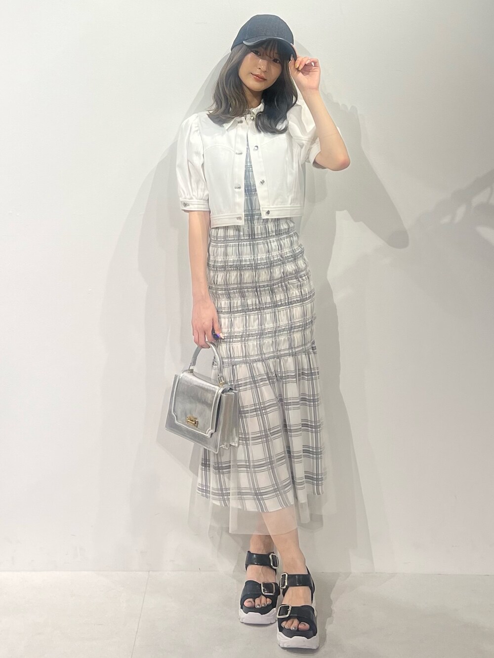 ブラック系のサンダル、ホワイト系のデニムジャケット、ホワイト系のワンピースを着用したレディースの春コーディネートの8枚目の写真