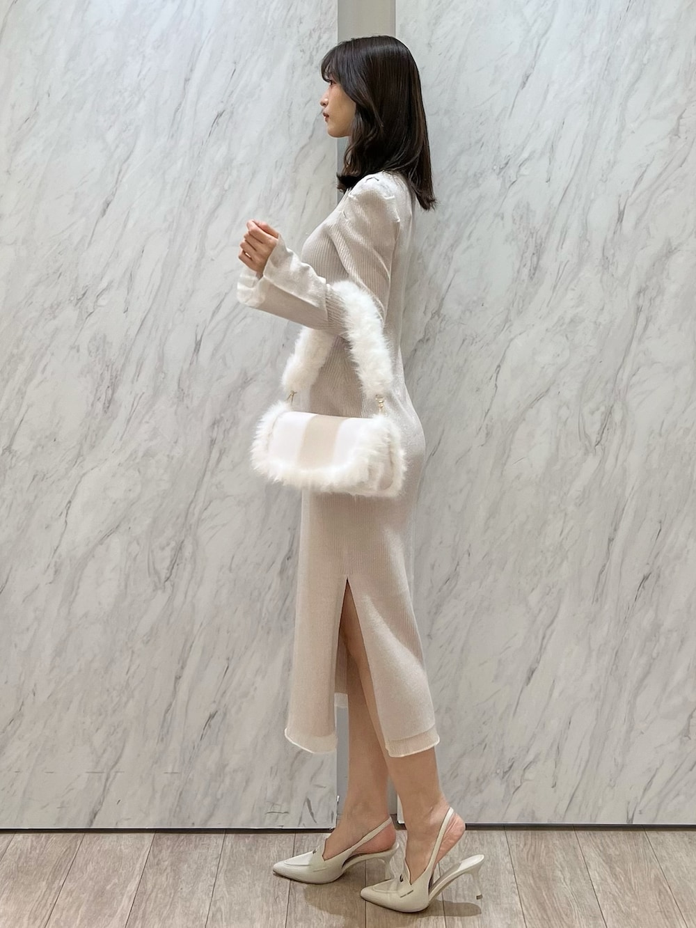 ホワイト系のワンピース、ホワイト系のショルダーバッグ、ホワイト系のパンプスを着用したレディースの冬コーディネートの3枚目の写真