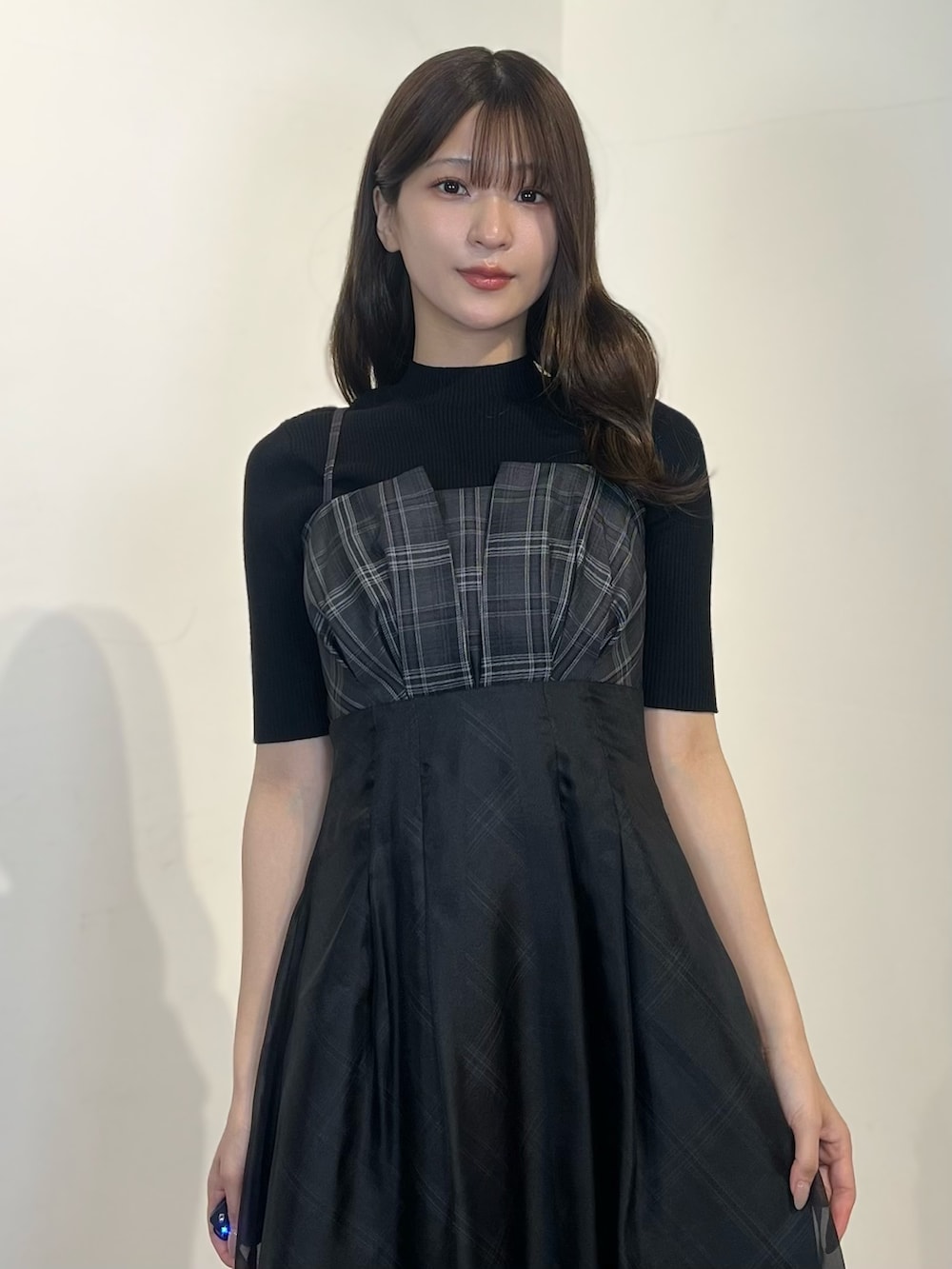 ブラック系のニット/セーター、ブラック系のワンピース、ブラック系のサンダルを着用したレディースの春コーディネートの5枚目の写真