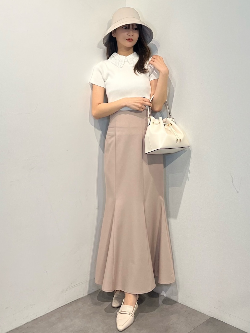 ホワイト系のニット/セーター、ピンク系のスカート、ホワイト系のパンプスを着用したレディースの春コーディネートの8枚目の写真