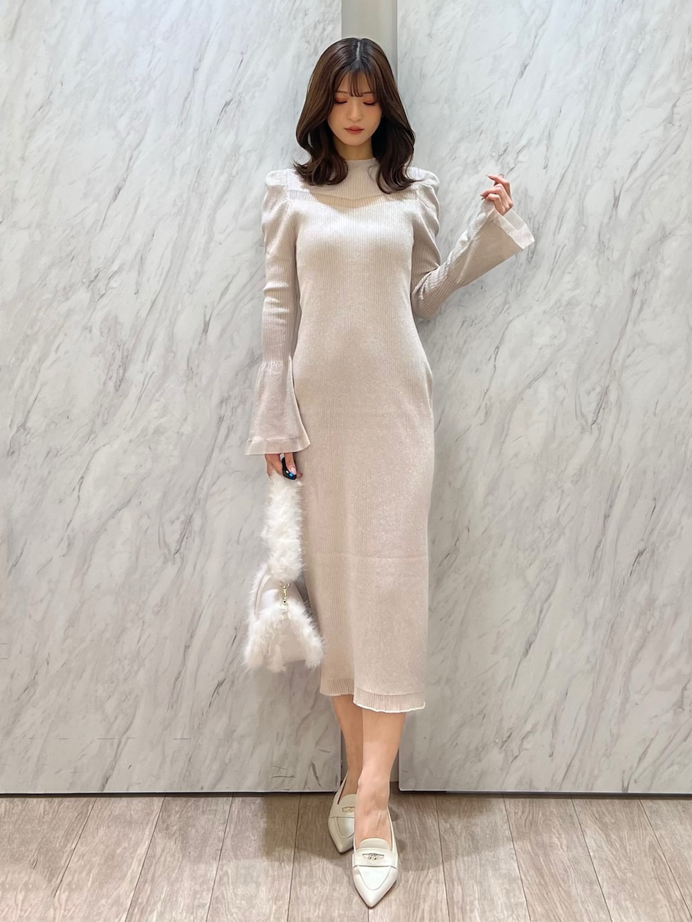 ホワイト系のワンピース、ホワイト系のショルダーバッグ、ホワイト系のパンプスを着用したレディースの冬コーディネートの5枚目の写真