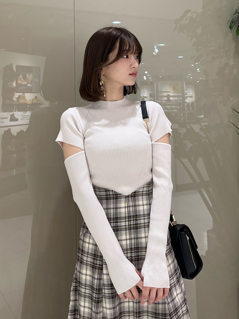 ホワイト系のニット/セーター、ブラウン系のテーラードジャケット、ブラウン系のスカートを着用したレディースの秋コーディネートの9枚目の写真