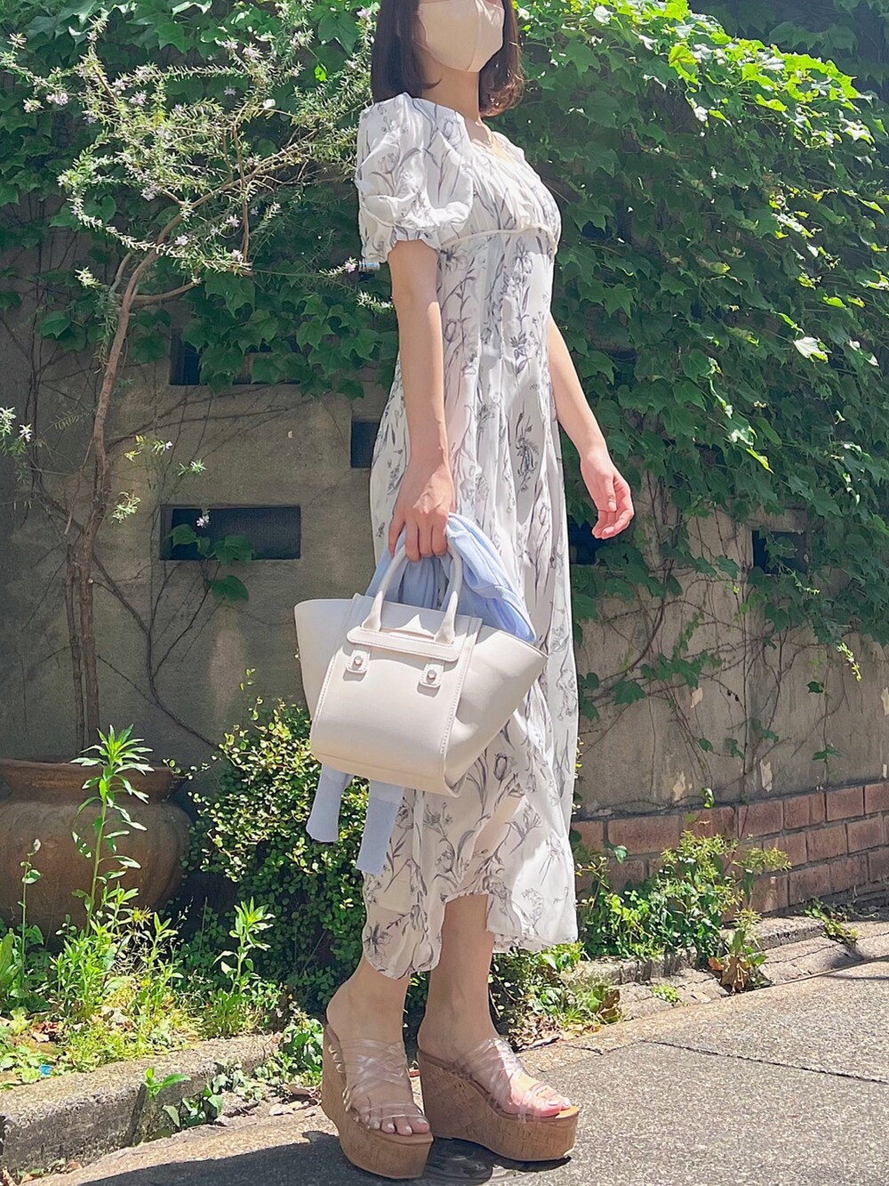 ホワイト系のワンピース、ブルー系のカーディガン/ボレロ、その他のサンダルを着用したレディースの春コーディネートの2枚目の写真