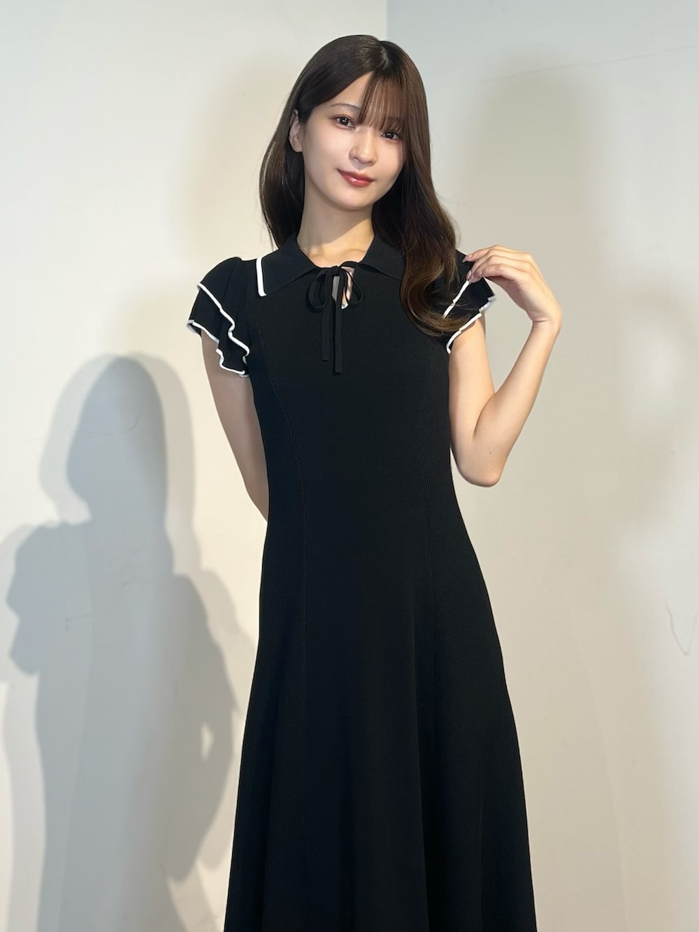 ブラック系のワンピース、ホワイト系のサンダルを着用したレディースの春コーディネートの3枚目の写真