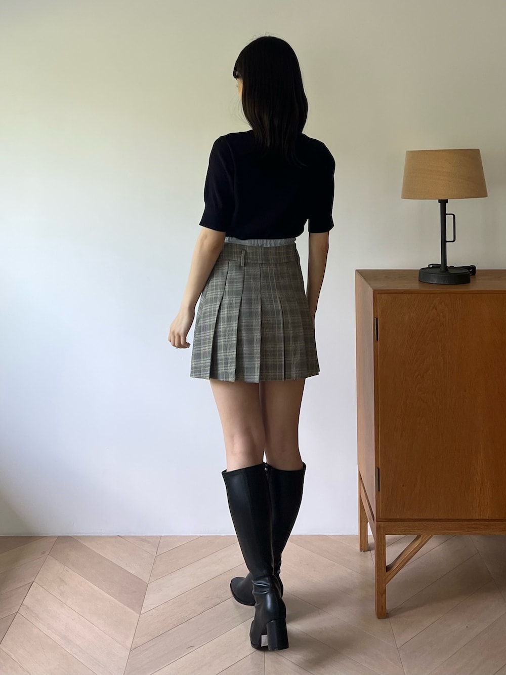 ブルー系のニット/セーター、グレー系のスカート、ブラック系のブーツを着用したレディースの夏コーディネートの3枚目の写真