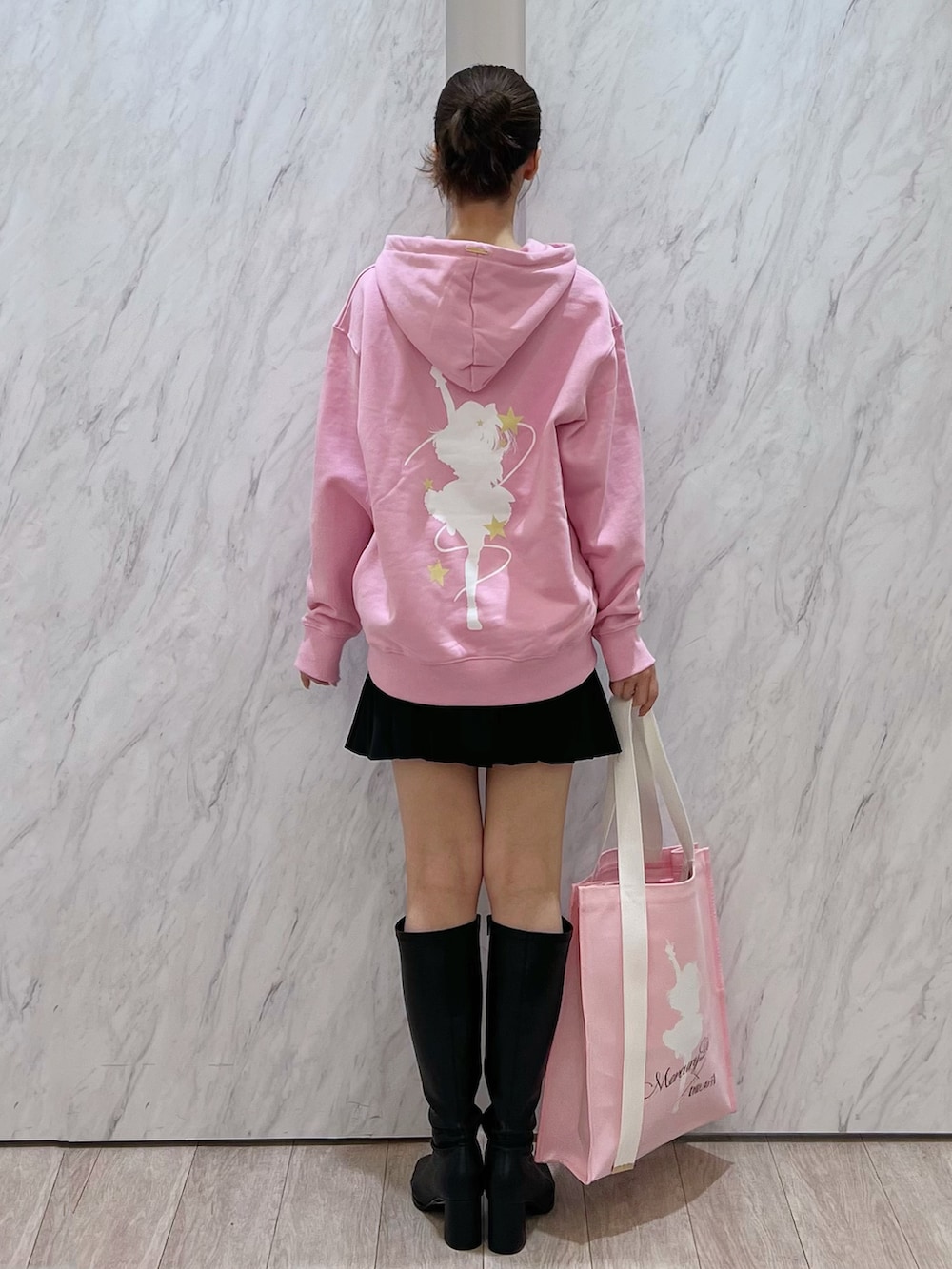 ピンク系のパーカー、ピンク系のトートバッグ、ブラック系のその他パンツを着用したレディースの秋コーディネートの4枚目の写真