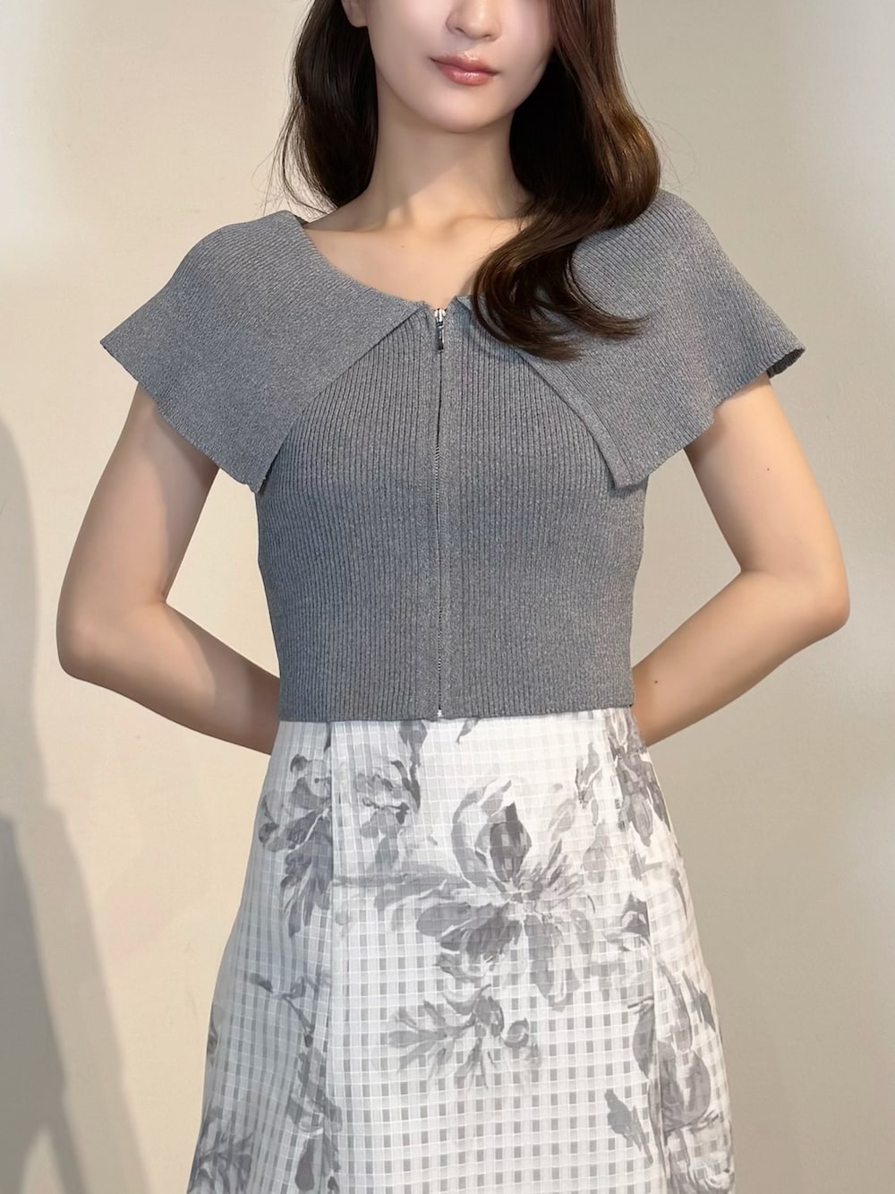ホワイト系のスカート、ホワイト系のサンダル、グレー系のニット/セーターを着用したレディースの春コーディネートの6枚目の写真