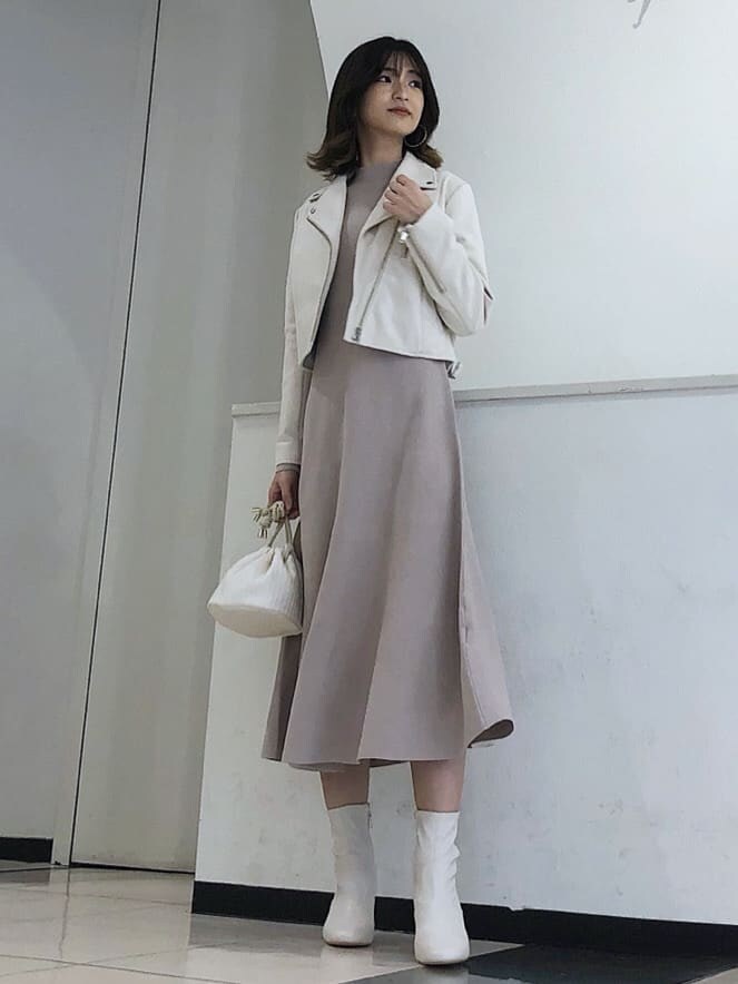 ホワイト系のハンドバッグ、ベージュ系のワンピース、ホワイト系のテーラードジャケットを着用したレディースの冬コーディネートの2枚目の写真