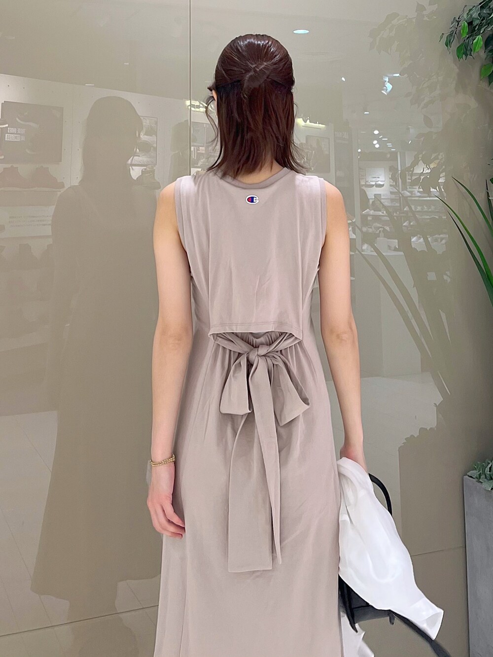 ベージュ系のワンピース、ブラック系のハンドバッグ、ブラック系のサンダルを着用したレディースの春コーディネートの5枚目の写真