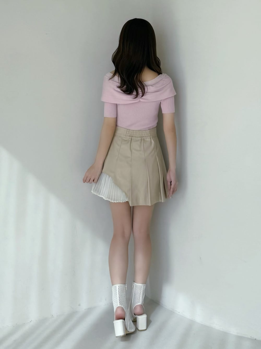 ベージュ系のスカート、ピンク系のニット/セーター、ホワイト系のブーツを着用したレディースの春コーディネートの5枚目の写真