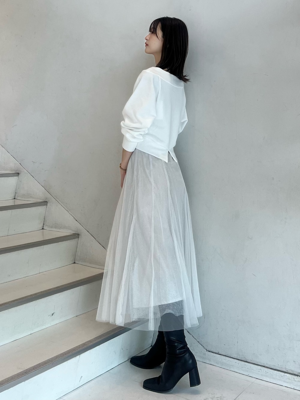 ブラウン系のショルダーバッグ、ホワイト系のスカート、ブラウン系のブーツを着用したレディースの秋コーディネートの4枚目の写真