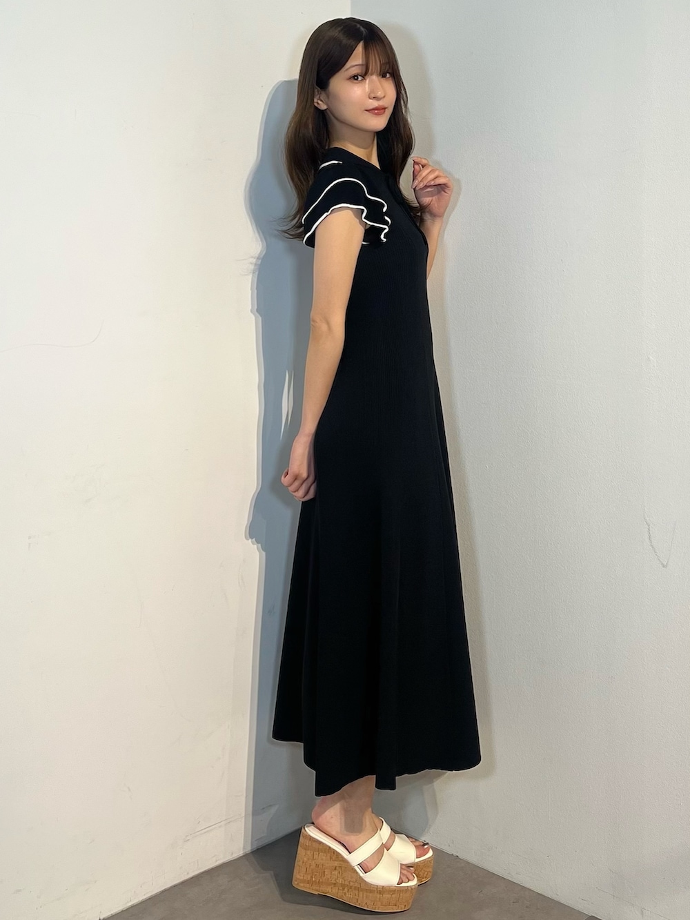 ブラック系のワンピース、ホワイト系のサンダルを着用したレディースの春コーディネートの2枚目の写真