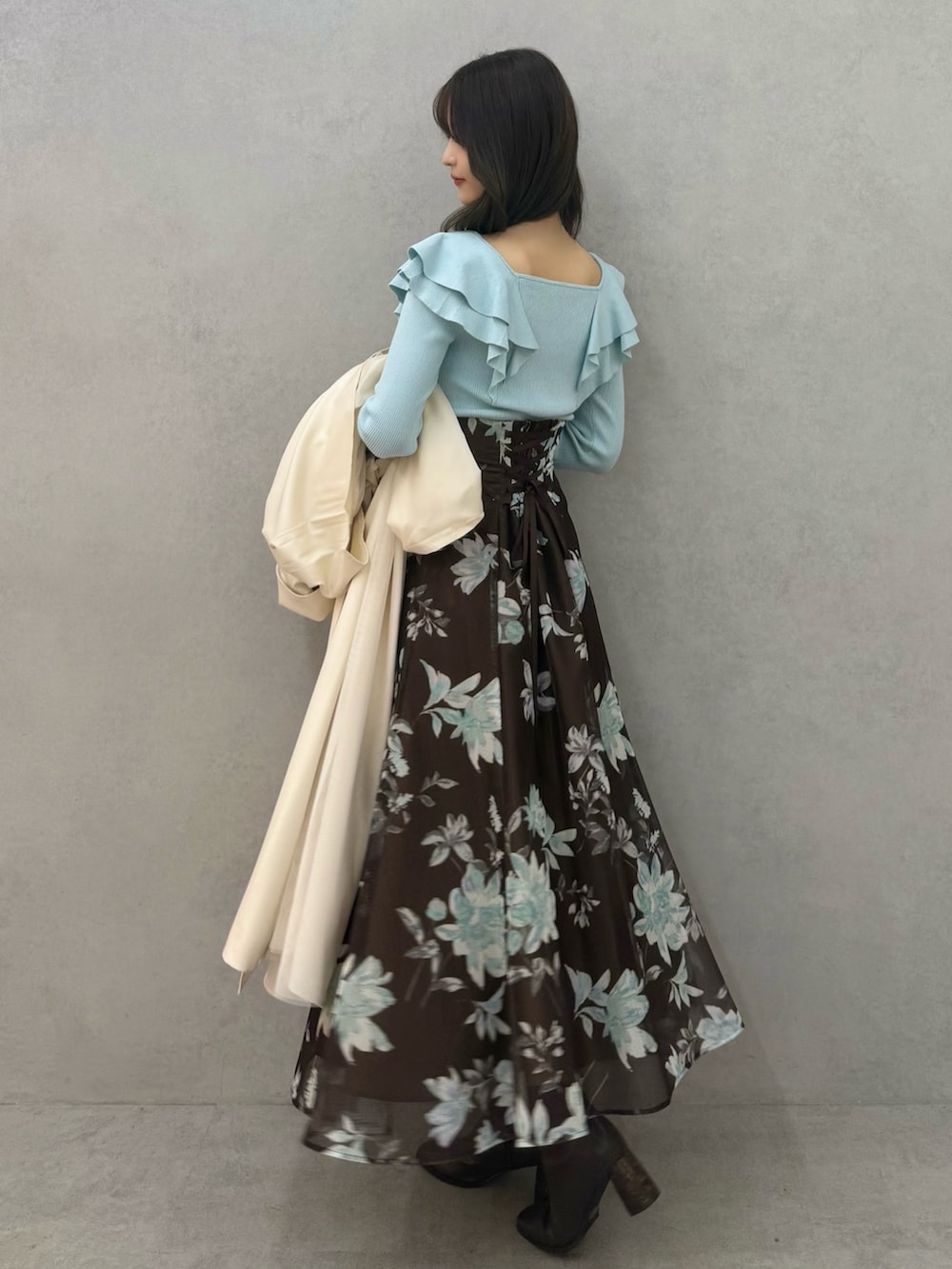 ブラウン系のブーツ、グリーン系のニット/セーター、ブラウン系のスカートを着用したレディースの春コーディネートの4枚目の写真