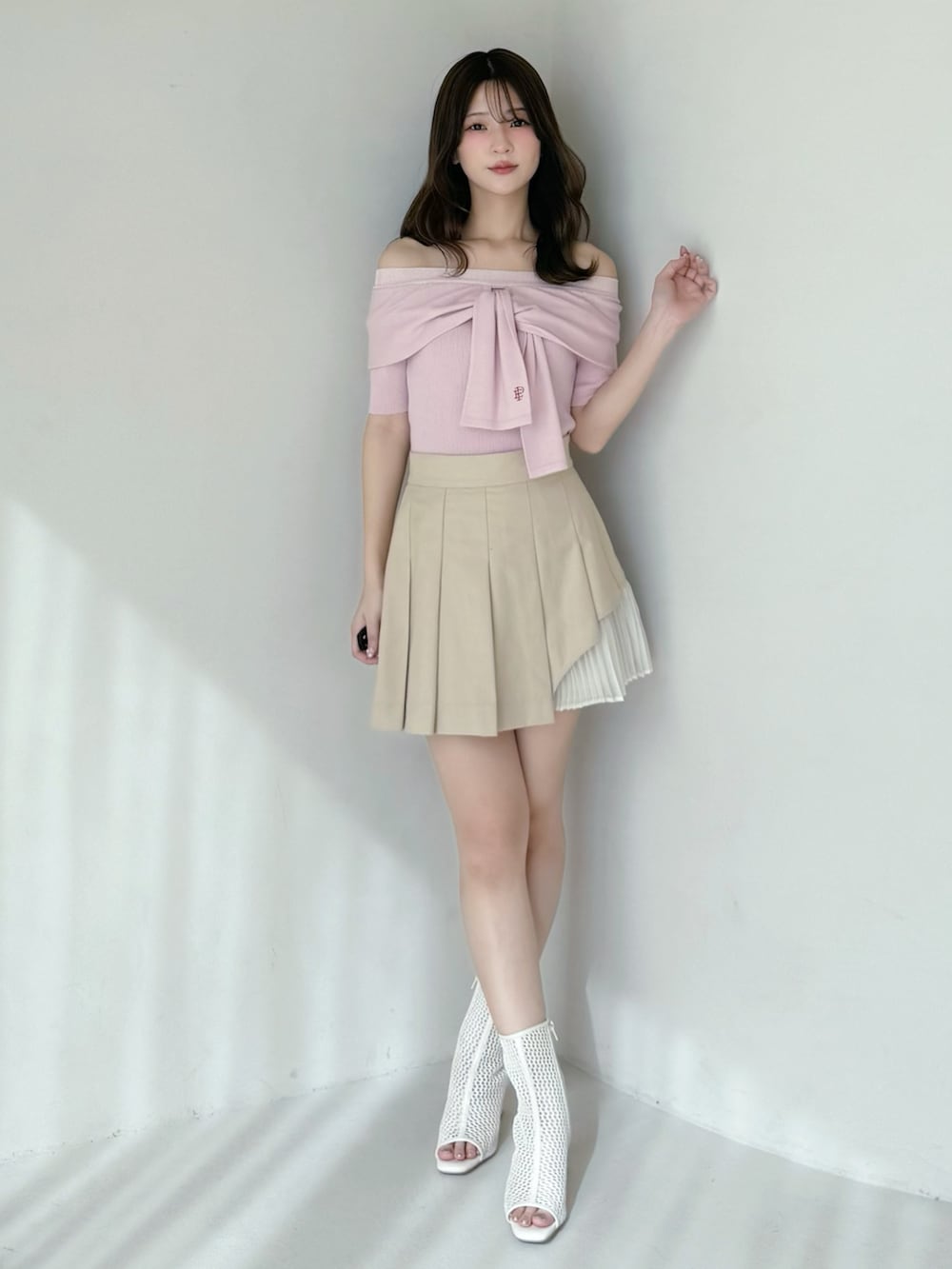 ベージュ系のスカート、ピンク系のニット/セーター、ホワイト系のブーツを着用したレディースの春コーディネートの6枚目の写真