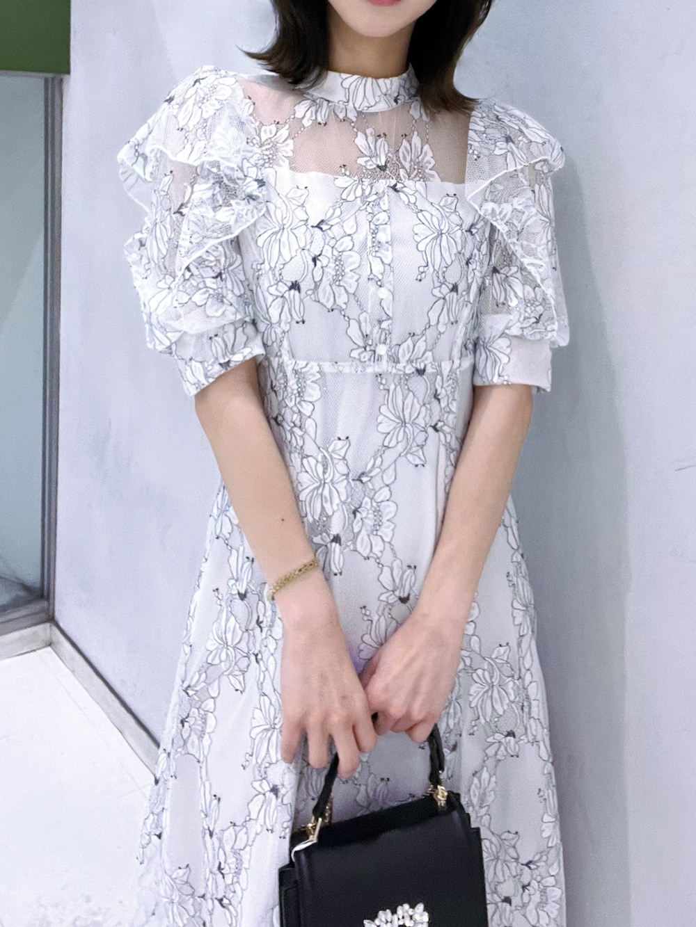 ブラック系のショルダーバッグ、ブラック系のサンダル、ホワイト系のワンピースを着用したレディースの夏コーディネートの5枚目の写真