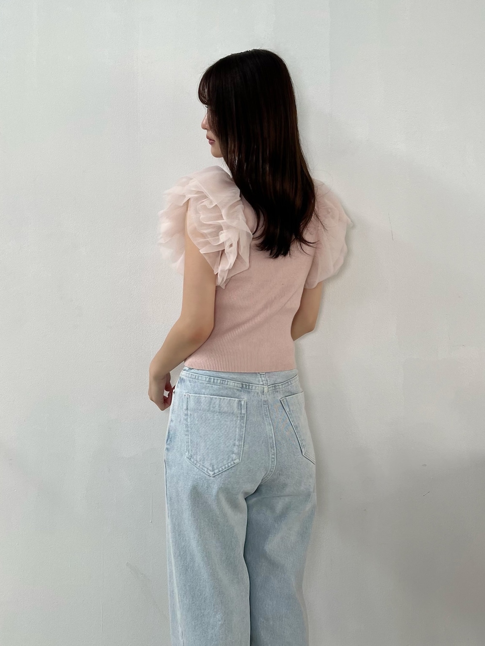 ピンク系のニット/セーター、ブルー系のデニムパンツ、その他のサンダルを着用したレディースの春コーディネートの4枚目の写真