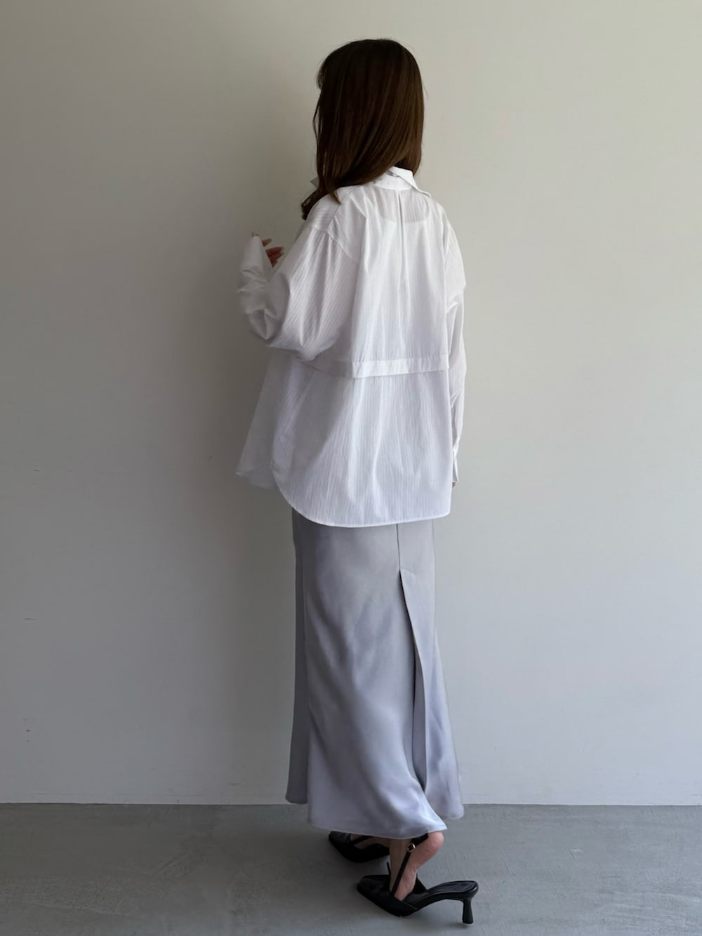 グレー系のスカート、ホワイト系のシャツ/ブラウス、ホワイト系のニット/セーターを着用したレディースの夏コーディネートの3枚目の写真