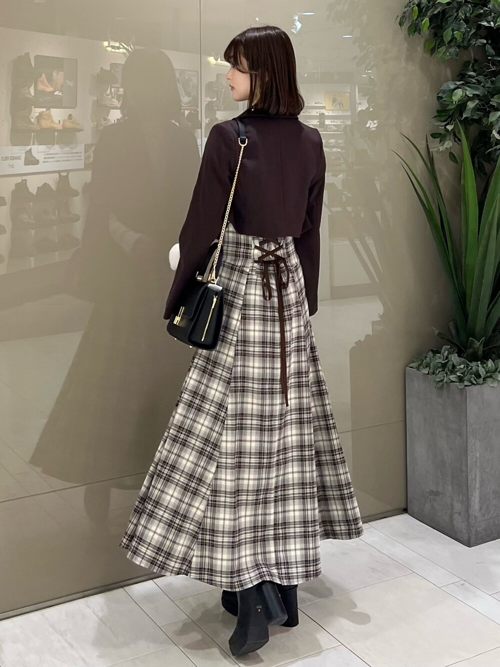 ホワイト系のニット/セーター、ブラウン系のテーラードジャケット、ブラウン系のスカートを着用したレディースの秋コーディネートの3枚目の写真