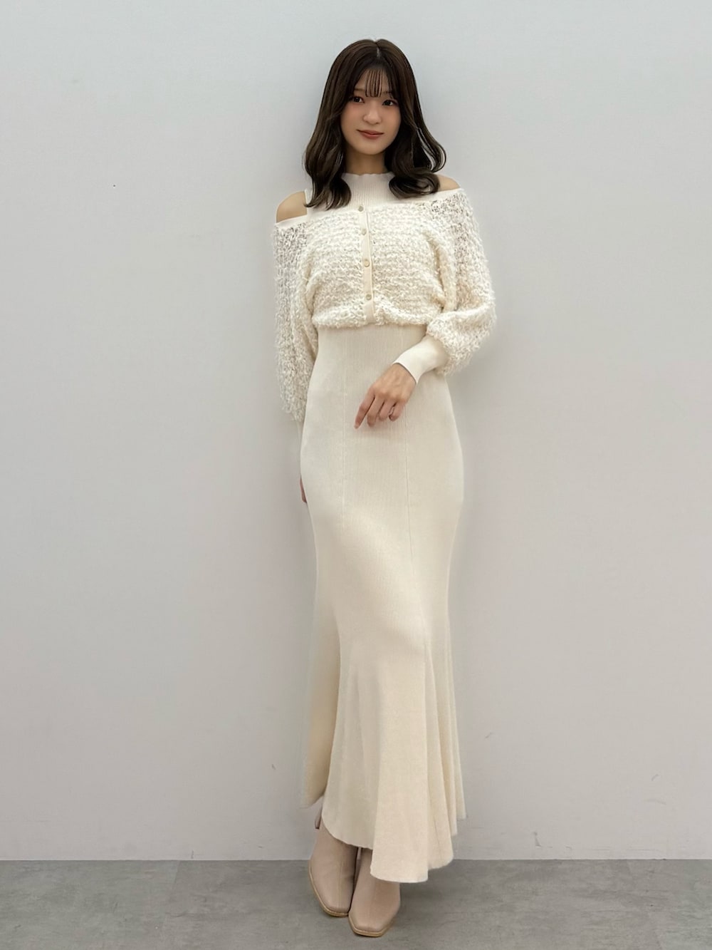 ブラック系のダウンジャケット/コート、ホワイト系のワンピース、ベージュ系のブーツを着用したレディースの秋コーディネートの3枚目の写真