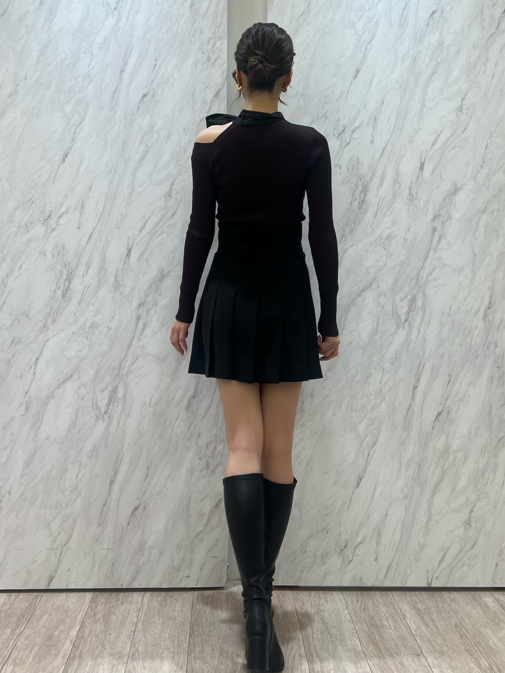 ブラウン系のニット/セーター、ブラック系のその他パンツ、ブラック系のブーツを着用したレディースの秋コーディネートの6枚目の写真