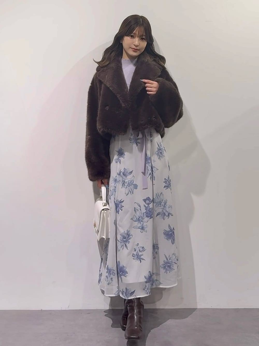 パープル系のワンピース、ブラウン系のブーツ、ホワイト系のハンドバッグを着用したレディースの秋コーディネートの7枚目の写真