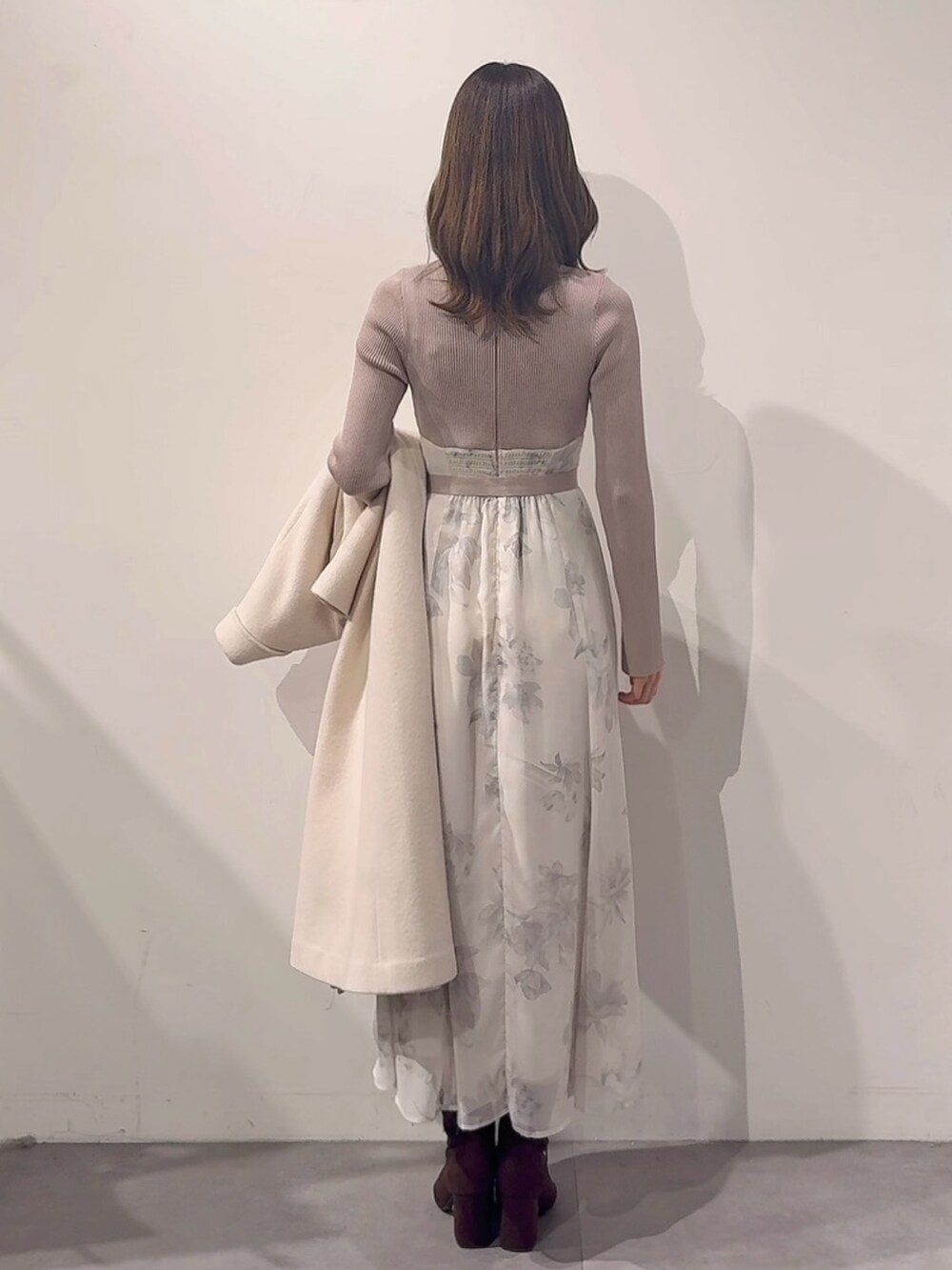 ホワイト系のその他アウター、ピンク系のハンドバッグ、ブラウン系のブーツを着用したレディースの秋コーディネートの7枚目の写真