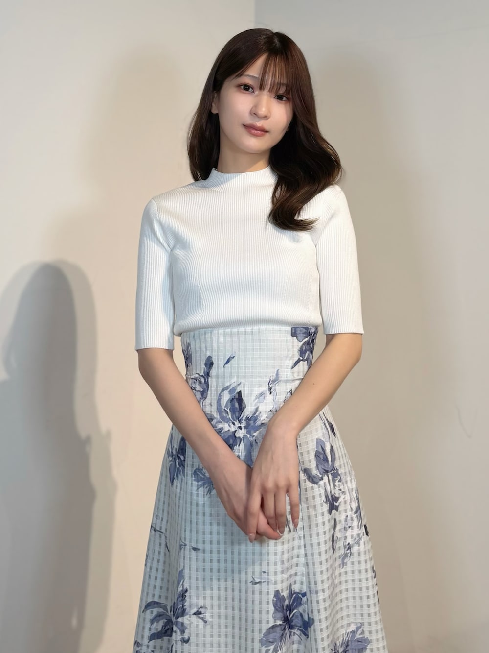 ホワイト系のニット/セーター、ブルー系のテーラードジャケット、ブルー系のスカートを着用したレディースの春コーディネートの10枚目の写真