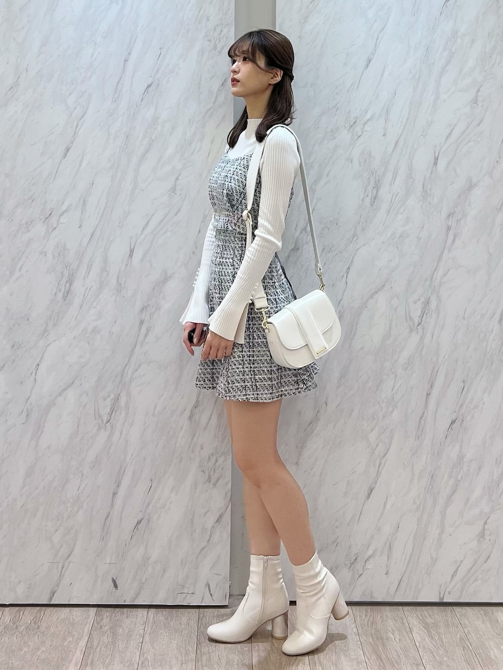 ホワイト系のニット/セーター、ブラック系のシャツ/ブラウス、ブラック系のスカートを着用したレディースの冬コーディネートの2枚目の写真