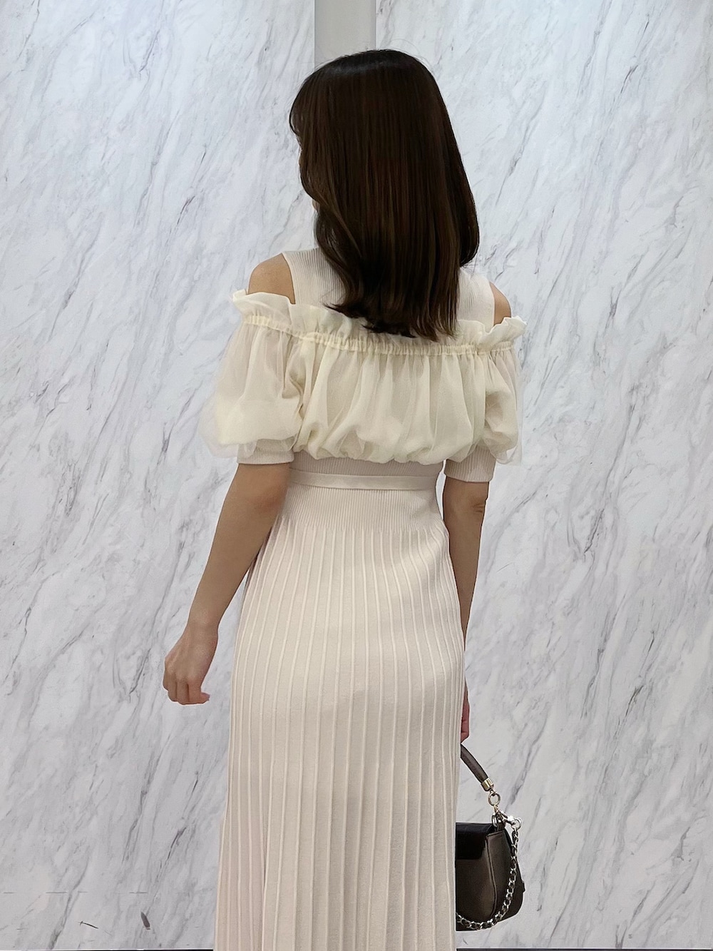 ホワイト系のワンピース、ブラウン系のブーツ、ブラウン系のハンドバッグを着用したレディースの春コーディネートの5枚目の写真