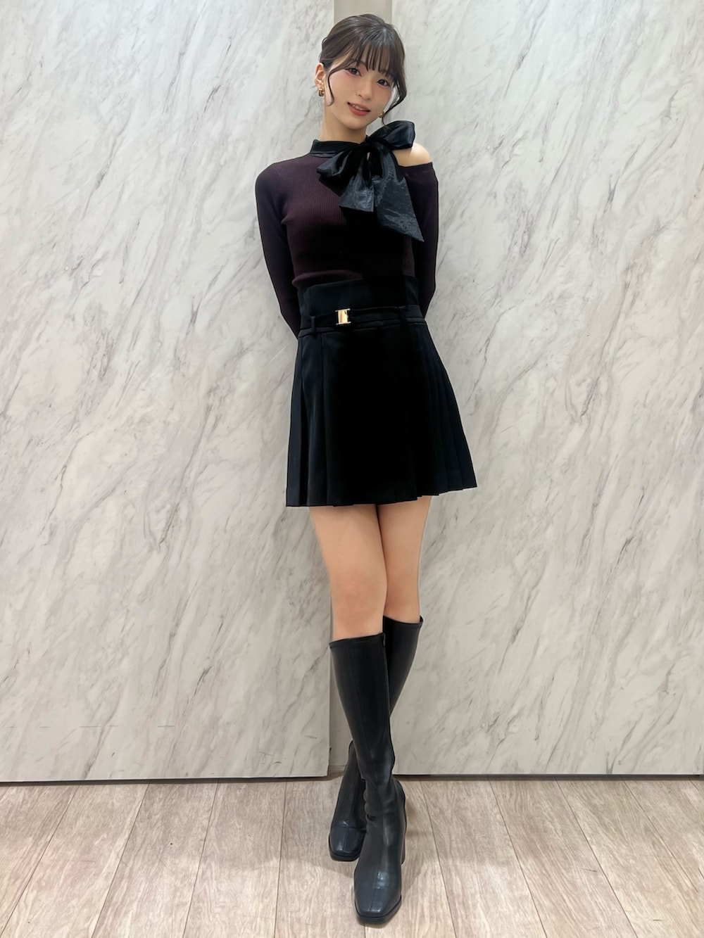 ブラウン系のニット/セーター、ブラック系のその他パンツ、ブラック系のブーツを着用したレディースの秋コーディネートの2枚目の写真