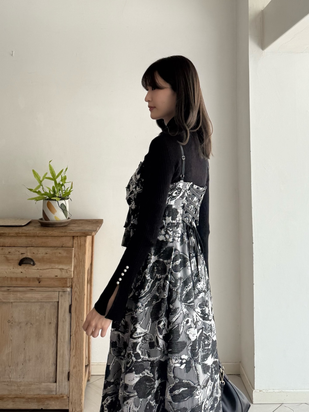 ブラック系のニット/セーター、ブラック系のワンピース、レッド系のブーツを着用したレディースの秋コーディネートの5枚目の写真