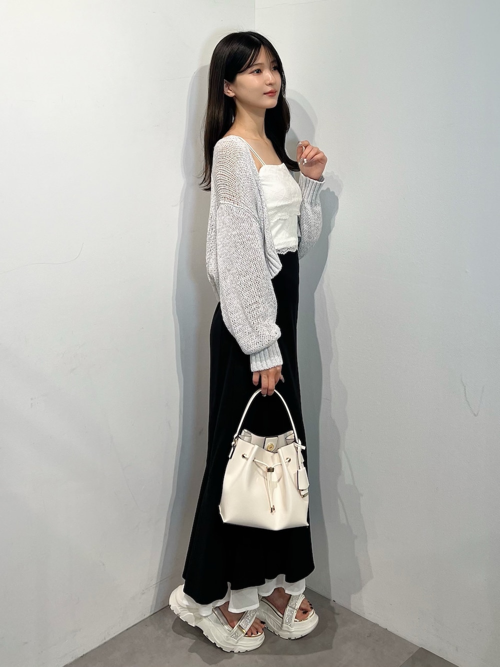 グレー系のカーディガン/ボレロ、ホワイト系のTシャツ/カットソー、ブラック系のスカートを着用したレディースの夏コーディネートの3枚目の写真