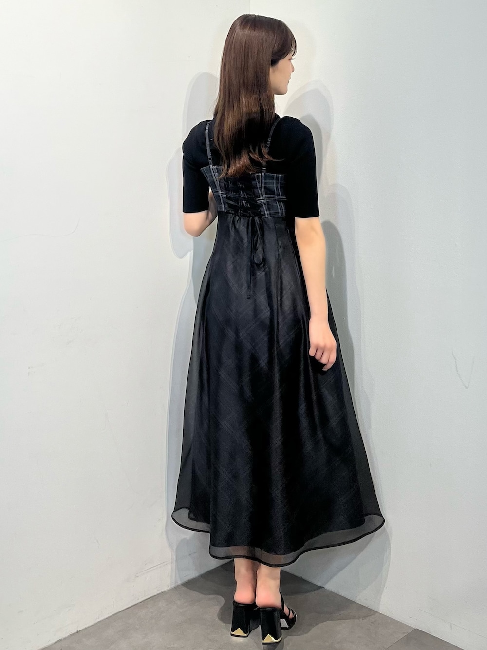 ブラック系のニット/セーター、ブラック系のワンピース、ブラック系のサンダルを着用したレディースの春コーディネートの4枚目の写真