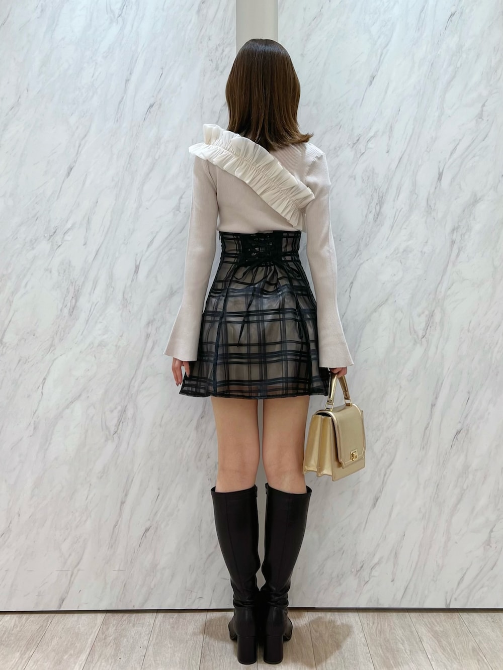 ホワイト系のニット/セーター、ブラック系のその他パンツ、ブラウン系のブーツを着用したレディースの秋コーディネートの2枚目の写真