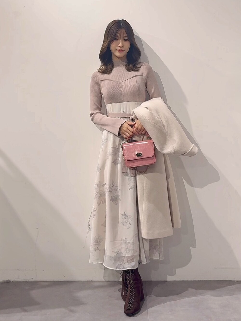 ホワイト系のその他アウター、ピンク系のハンドバッグ、ブラウン系のブーツを着用したレディースの秋コーディネートの5枚目の写真