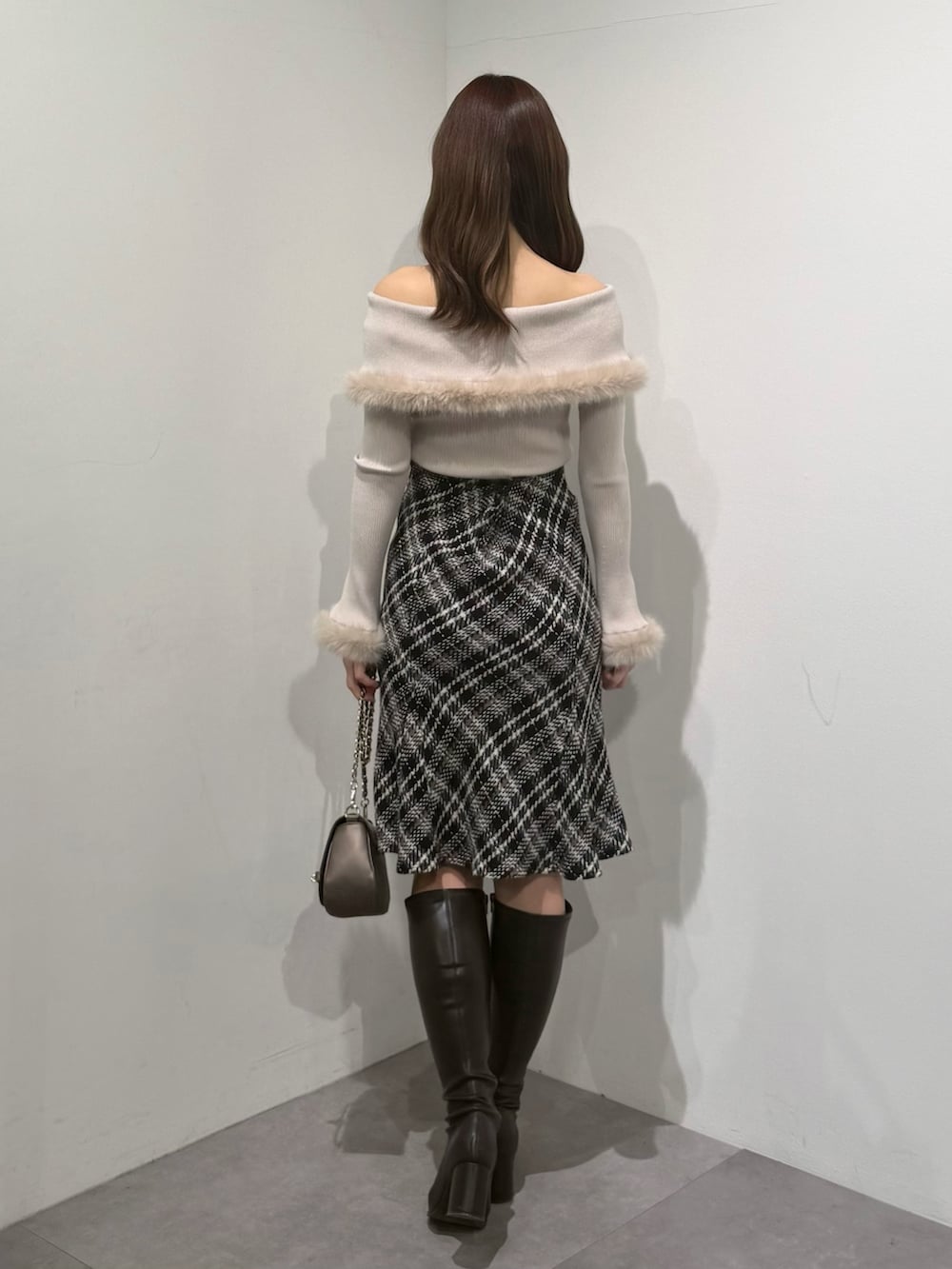 ベージュ系のニット/セーター、ブラック系のスカート、ブラウン系のブーツを着用したレディースの冬コーディネートの4枚目の写真