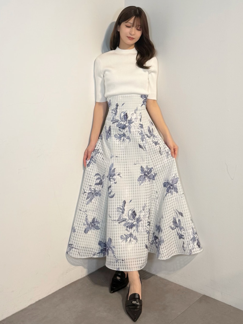 ホワイト系のニット/セーター、ブルー系のテーラードジャケット、ブルー系のスカートを着用したレディースの春コーディネートの7枚目の写真