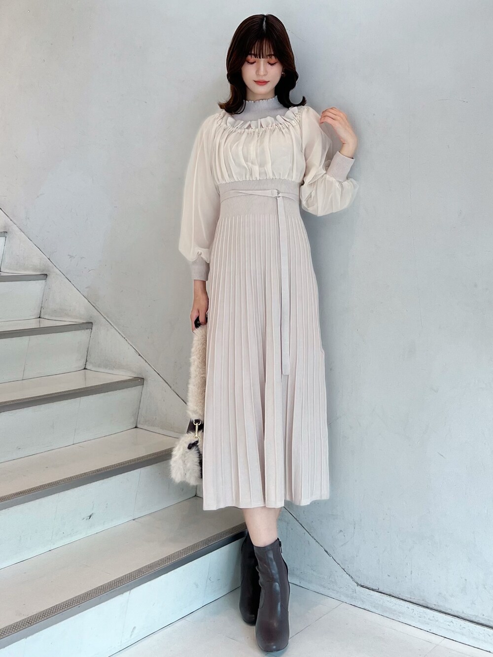 ホワイト系のワンピース、ブラウン系のショルダーバッグ、ブラウン系のブーツを着用したレディースの秋コーディネートの2枚目の写真