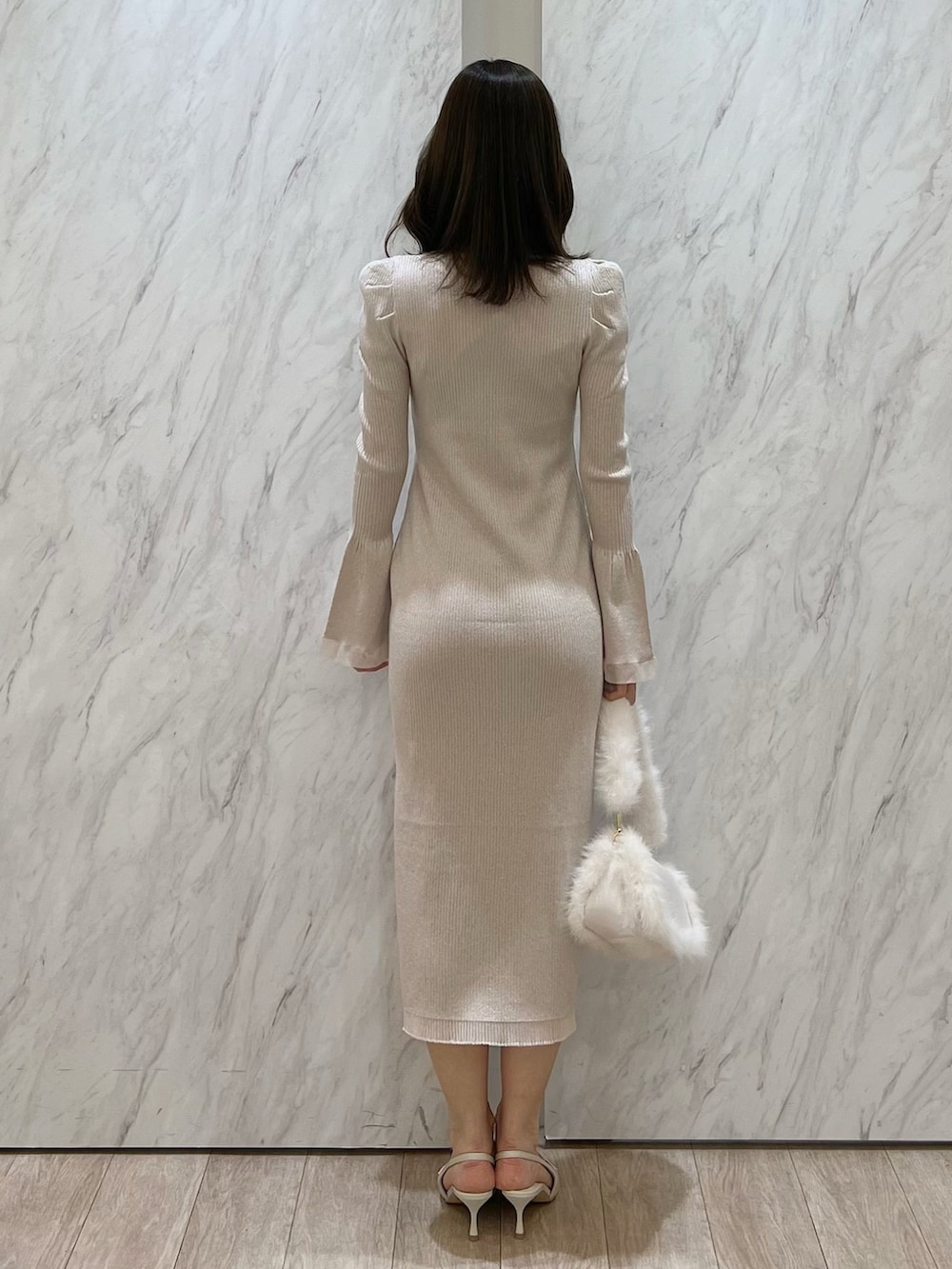 ホワイト系のワンピース、ホワイト系のショルダーバッグ、ホワイト系のパンプスを着用したレディースの冬コーディネートの4枚目の写真