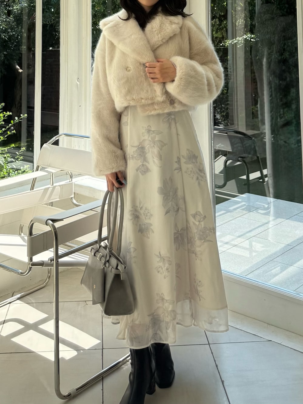 ベージュ系のワンピース、グレー系のハンドバッグ、ブラック系のブーツを着用したレディースの秋コーディネートの5枚目の写真