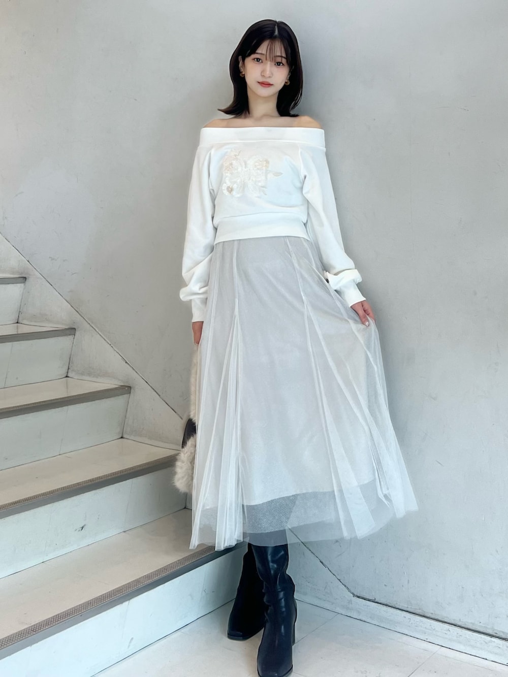 ブラウン系のショルダーバッグ、ホワイト系のスカート、ブラウン系のブーツを着用したレディースの秋コーディネートの6枚目の写真